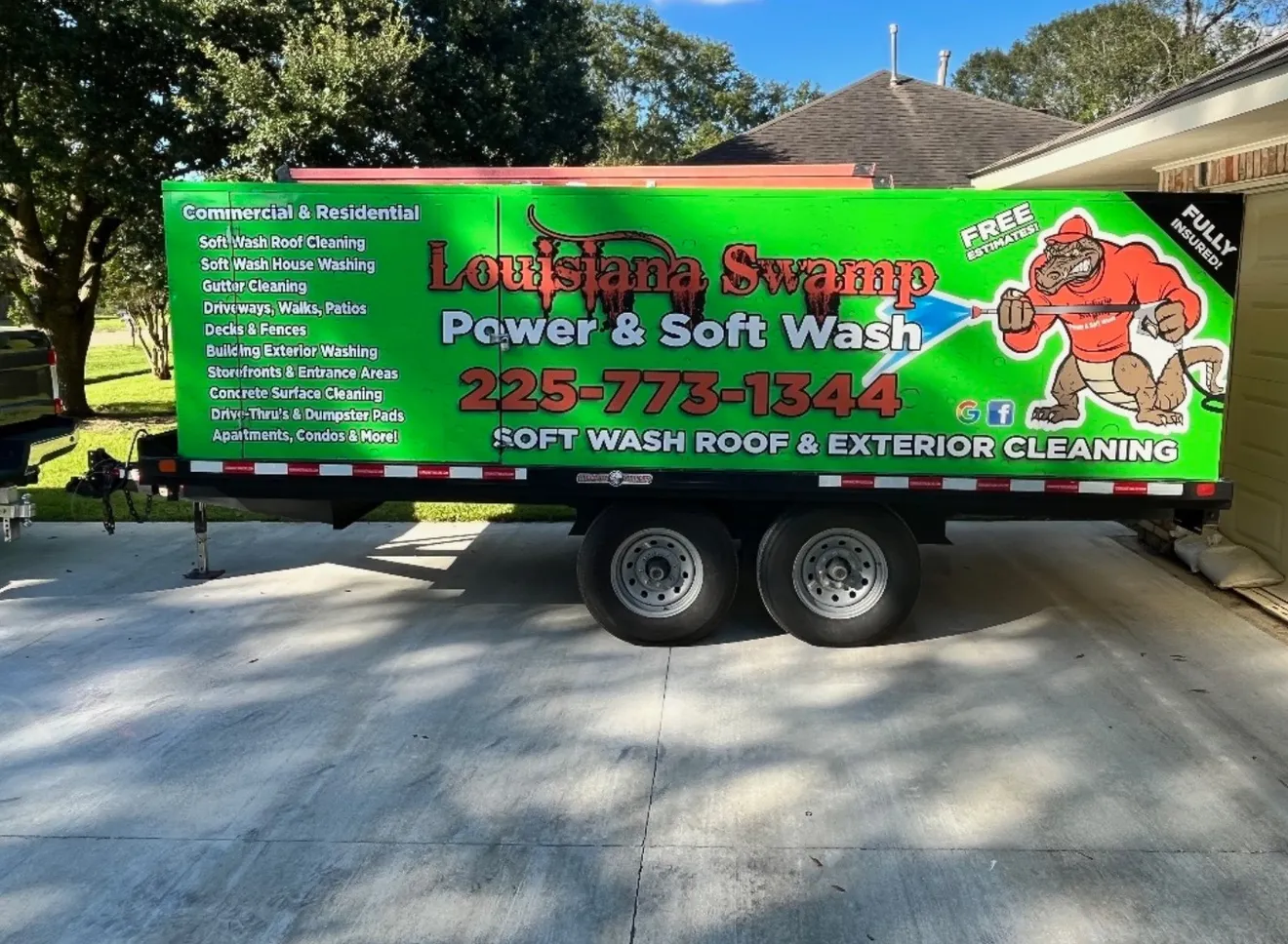 The wrapped Louisiana Swamp Power & Soft Wash trailer parked at a job in the Baton Rouge area