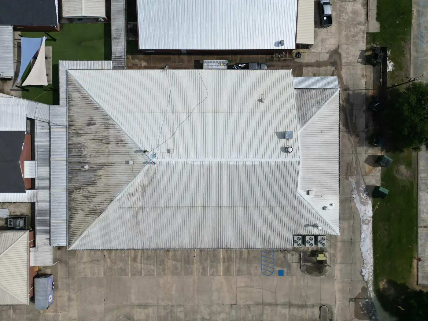 The same commercial metal roof after cleaning, now a uniform light silver.