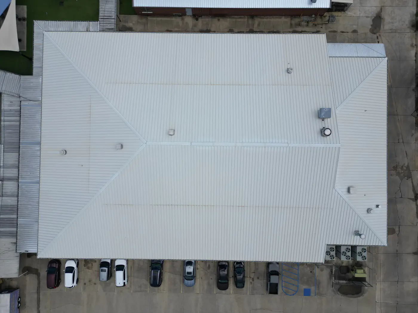 Aerial view of the Denham Springs High School cafeteria metal roof after soft washing, a clean, uniform silver.