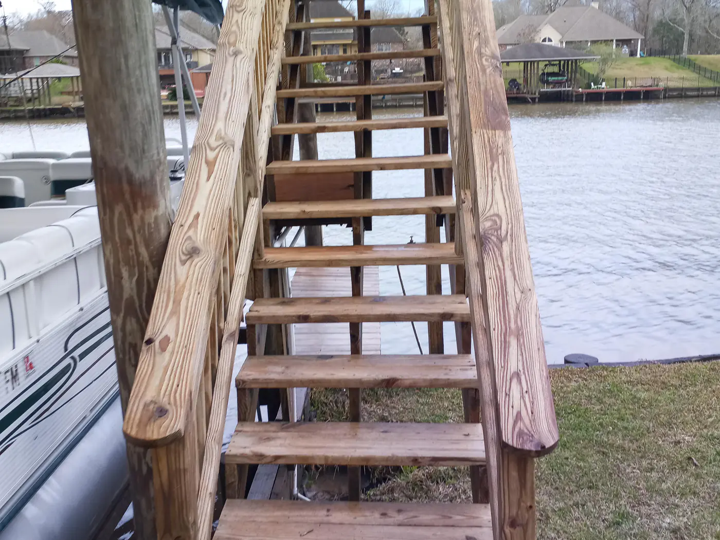 The same dock staircase after cleaning, restored to clean, light natural wood.