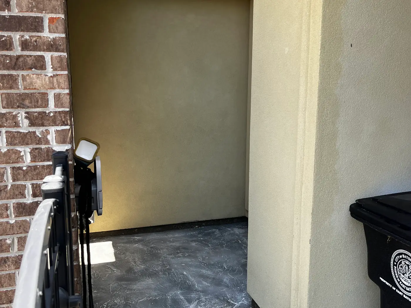 The same alcove after soft washing, with a clean cream wall and clean concrete.